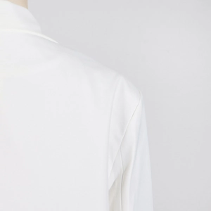Détail des coutures et du tissu tissé sur l'épaule de la robe blazer blanche