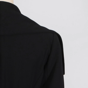 Close-up of black trench coat shoulder with lapel collar and padded shoulder structure