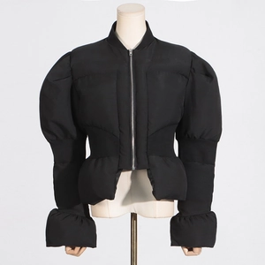 Détails de la veste noire ajustée avec manches bouffantes, volants et fermeture éclair argent