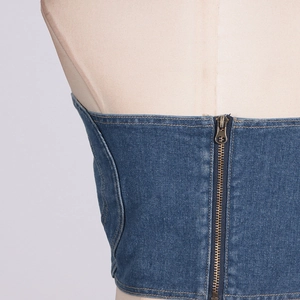 Dettaglio della chiusura con cerniera in metallo sul retro del top bustier in denim