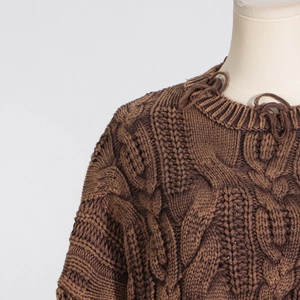 Close-up of distressed ripped neckline on cable knit sweater in dark coffee brown