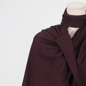 Close-up of deep burgundy shawl draped on a mannequin showing rich fabric texture