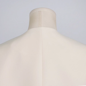 Detailed back seam stitching of a minimalist cream white blazer on a mannequin
