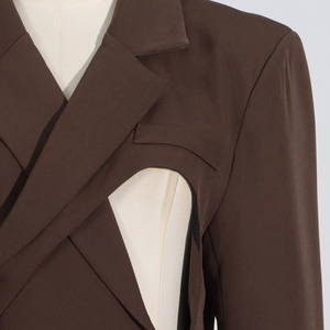 Détail d'un blazer marron foncé tendance avec des découpes et un design croisé