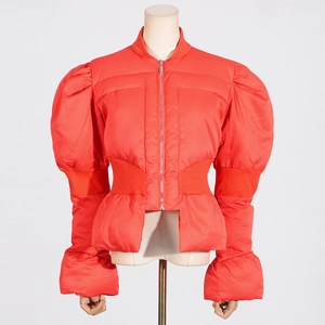 Détail de la doudoune orange corail avec manches bouffantes et taille cintrée élégante