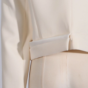 Detailed view of beige suit blazer back waist folding design and fabric texture