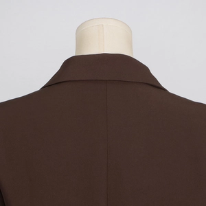 Détail du col arrière d'une veste de tailleur marron foncé en tissu tissé lisse