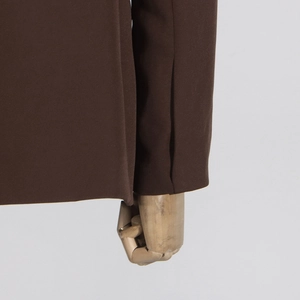 Vue détaillée de la manche d'un blazer marron avec coutures de qualité et tissu fin