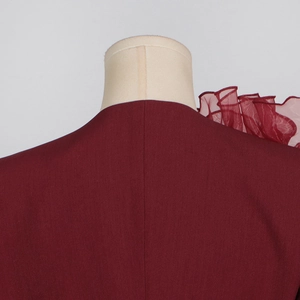 Detail eines burgunderroten Blazers mit Organza-Rüschen an der Schulterpartie