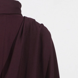 Detail of burgundy trench coat showing elegant stand collar and pleated shoulder seams