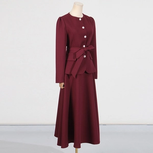 Detail view of burgundy slim fit top and skirt set with elegant pearl buttons and bow belt