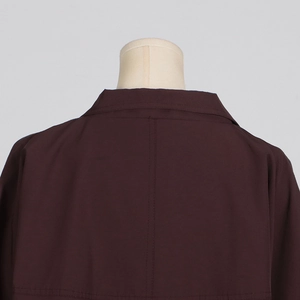 Close-up of the back collar and shoulder seams of a premium dark brown long trench coat