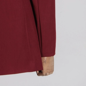 Detailaufnahme von weinrotem Blazer-Ärmel und Saum mit feiner Webstoff-Textur