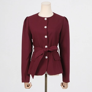 Detailed view of the dark red blazer featuring pearl buttons and a waist-cinching tie