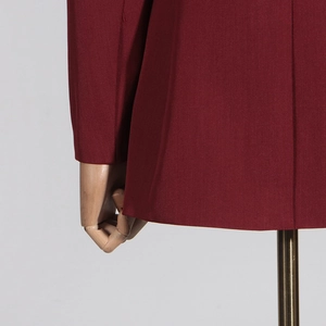Detailansicht des dunkelroten Blazers mit Fokus auf Nähten und Mescheinsätzen