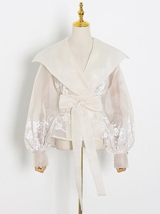 Elegant off-white organza blouse with puff sleeves and lace details on white background