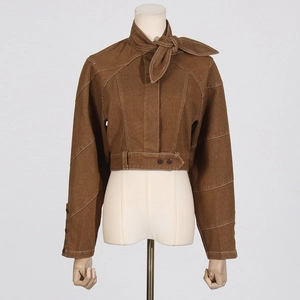 Detail of a brown cropped jacket featuring white contrast stitching and a neck-tie design
