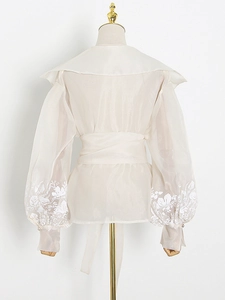 Back view of elegant ivory floral blouse with lantern sleeves and embroidered details