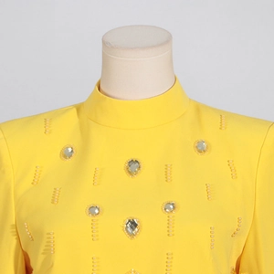 Détail macro du col montant jaune vif avec perles exquises et cristaux de luxe pour femme