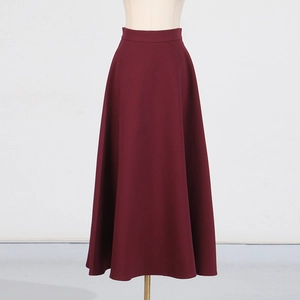 Detail of a high-waisted dark red A-line long skirt with a smooth minimalist silhouette