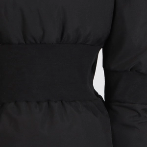 Détail macro de la veste matelassée noire avec une large taille en tricot côtelé élastique