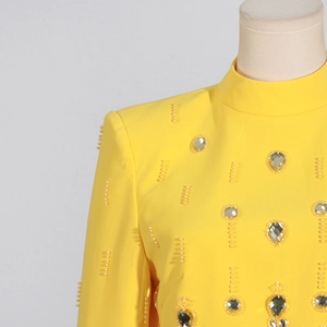 Détail du haut à col montant jaune avec perles blanches et accents de strass en cœur