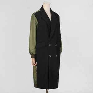 Detail of color-block trench coat with olive green sleeves and black suit fabric