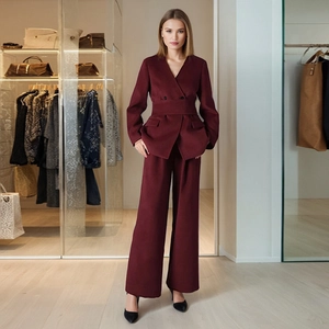 Detail of burgundy two-piece suit showing belted waist and wool texture on wide-leg pants