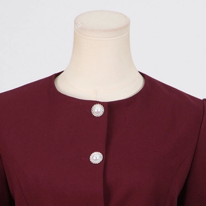 Close-up of burgundy top featuring elegant pearl buttons with rhinestone trim and round neck