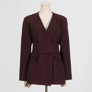 Detail of burgundy wool-blend coat with v-neck and waist-defining belt buckle