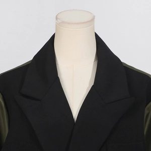 Detail of contrast lapel design on stylish black and dark green trench coat jacket