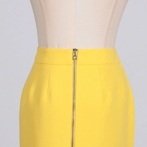 Détail de la fermeture éclair métallique et de la taille haute sur une jupe longue jaune