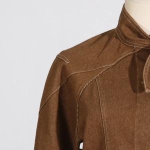 Detail of brown long sleeve jacket with textured twill fabric and white contrast stitching