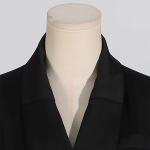 Dettaglio del collo di un elegante abito blazer nero con sartoria precisa su manichino