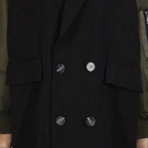 Detail view of the contrast color stitching and metal zipper pocket on the sleeve