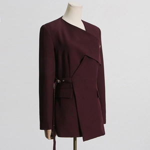 Detail of burgundy asymmetrical blazer with metal buckle belt and layered hemline