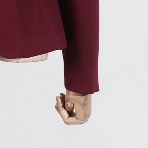 Detailed close-up showing the premium burgundy fabric texture and neat stitching of the suit