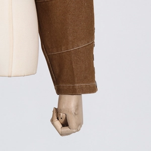 Close-up of brown twill jacket cuff with white contrast stitching and metal button details