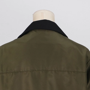 Close-up of contrast black collar and stitching on the back of an army green trench coat