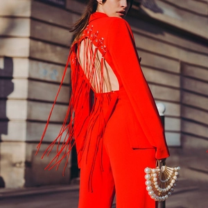 Macro view of red backless blazer with fringe tassels and sparkling rhinestone details