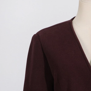 Detailed view of the V-neckline and shoulder tailoring on a burgundy long sleeve top