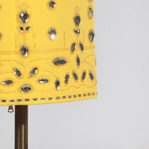 Vue macro de détail de robe jaune avec broderie exquise de strass floraux étincelants