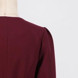 Close-up of wine red slim top showing pleated puff sleeve shoulder and woven texture