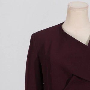Close-up detail of dark purple irregular blazer with collarless design and shoulder tailoring