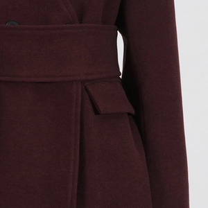Detailed macro shot of burgundy wool coat texture with belt and flap pocket details