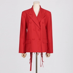 Detail of red double-breasted blazer featuring unique long fringe trim on the hemline