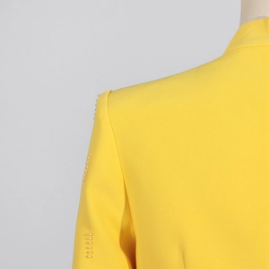 Détail de la robe jaune avec des perles blanches le long de l'épaule et de la couture
