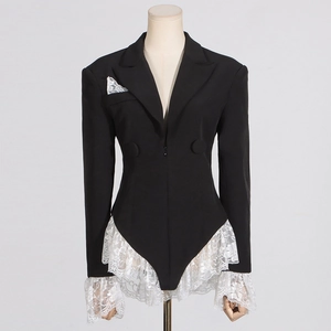 Detailed close-up of white lace ruffles and floral embroidery on a black blazer romper