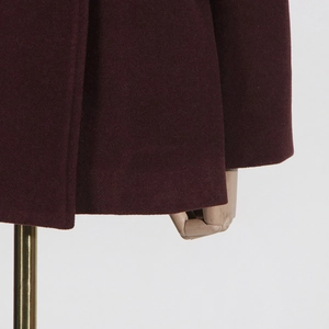 Macro shot of burgundy wool coat showing smooth texture and premium stitching details