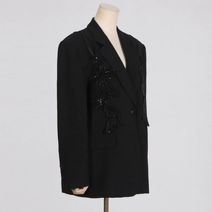 Detailed view of black blazer with heavy sequin butterfly patchwork and premium texture